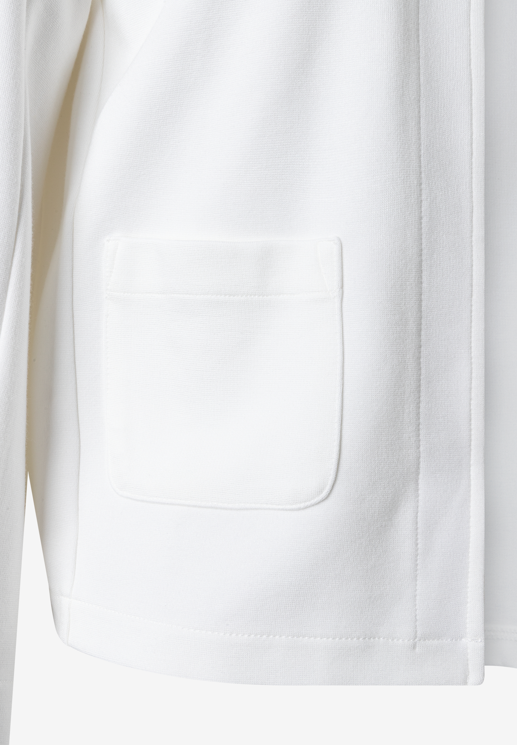 Detailaufnahme eines weißen MORE & MORE Tops mit einer aufgesetzten Tasche. Detailaufnahme eines weißen MORE & MORE Tops mit einer aufgesetzten Tasche.