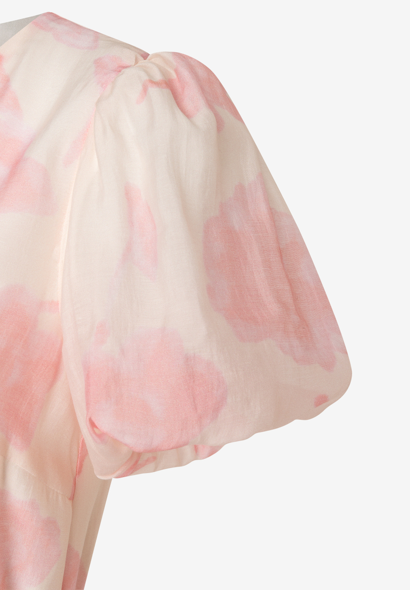 Ein Ausschnitt eines MORE & MORE Oberteils aus Chiffon mit rosa Muster auf hellem Grund. Ein Ausschnitt eines MORE & MORE Oberteils aus Chiffon mit rosa Muster auf hellem Grund.