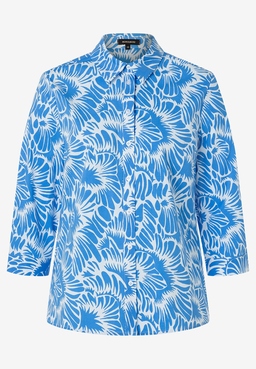 Eine hellblaue MORE & MORE Bluse mit weißen, floralen Mustern und 3/4-Ärmeln. Eine hellblaue MORE & MORE Bluse mit weißen, floralen Mustern und 3/4-Ärmeln.