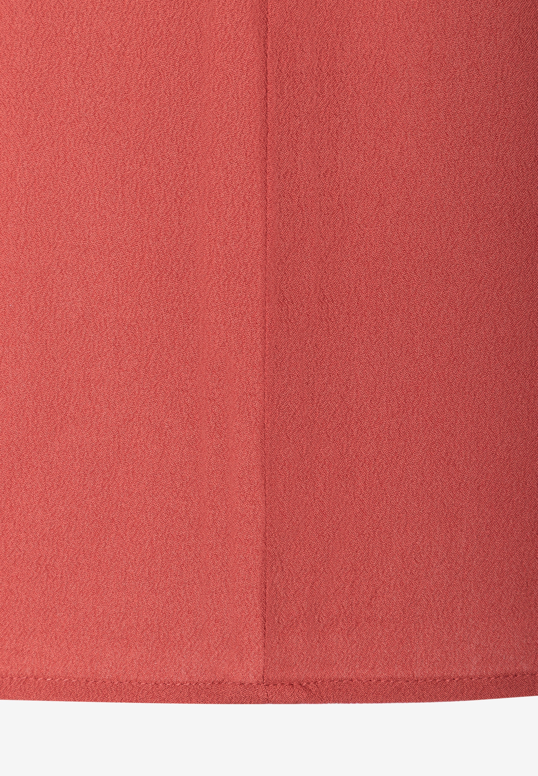 MORE & MORE Bluse: Detailansicht des roten, fließenden Webware-Stoffs mit Naht in der Mitte und Saum am unteren Rand. MORE & MORE Bluse: Detailansicht des roten, fließenden Webware-Stoffs mit Naht in der Mitte und Saum am unteren Rand.