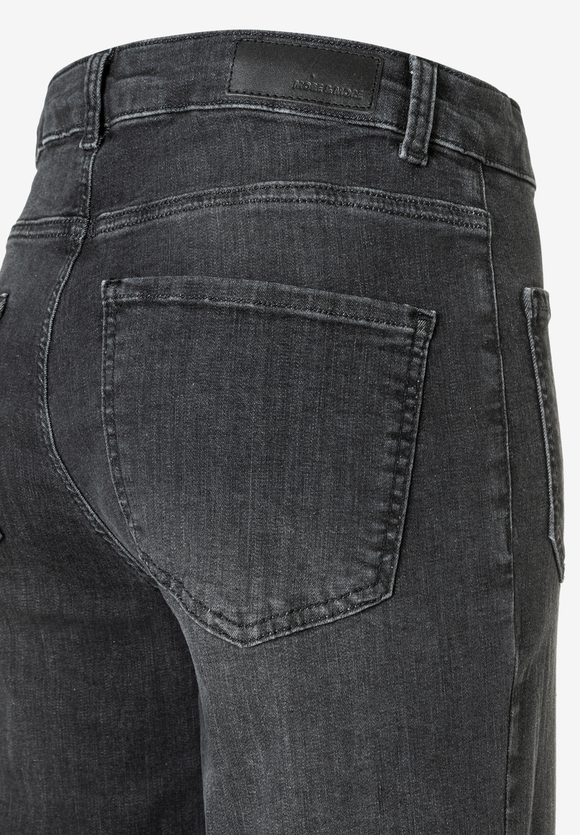 Nahaufnahme der Rückseite einer grauen MORE & MORE Jeanshose aus Denim mit Tasche. Nahaufnahme der Rückseite einer grauen MORE & MORE Jeanshose aus Denim mit Tasche.