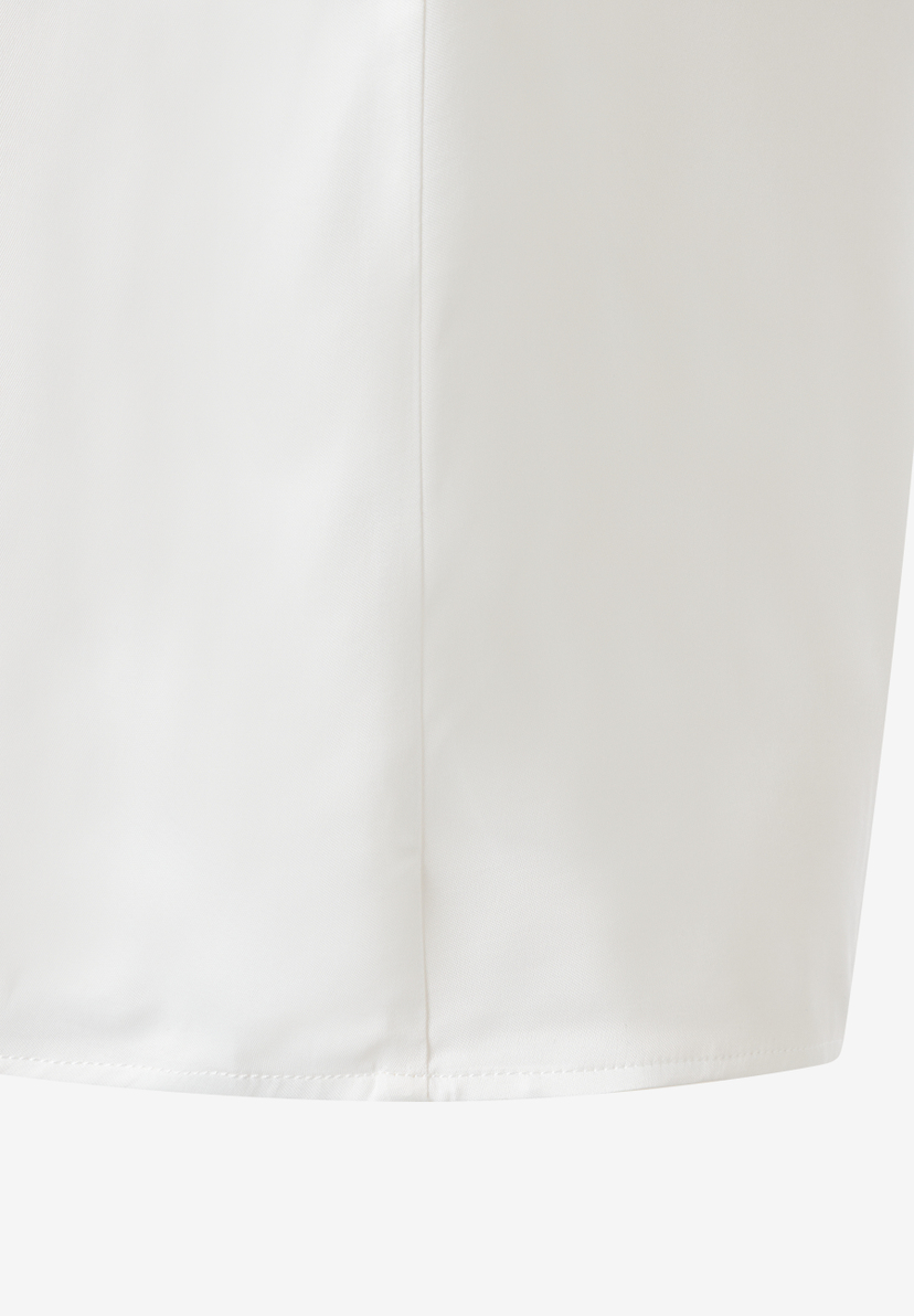 Detailaufnahme einer weißen MORE & MORE Bluse mit Saum und Naht. Detailaufnahme einer weißen MORE & MORE Bluse mit Saum und Naht.