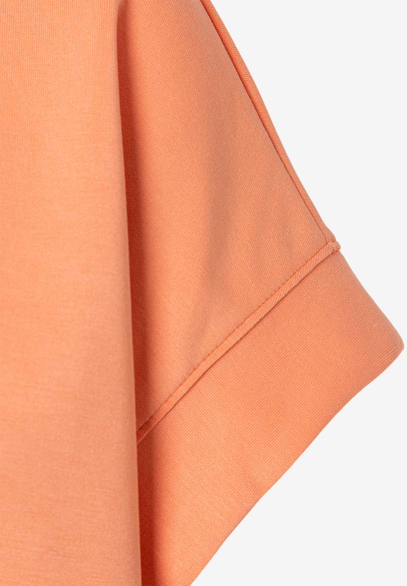 Nahaufnahme eines MORE & MORE Sweatshirts in Pfirsich mit elastischem, angenehmen Tragekomfort. Nahaufnahme eines MORE & MORE Sweatshirts in Pfirsich mit elastischem, angenehmen Tragekomfort.