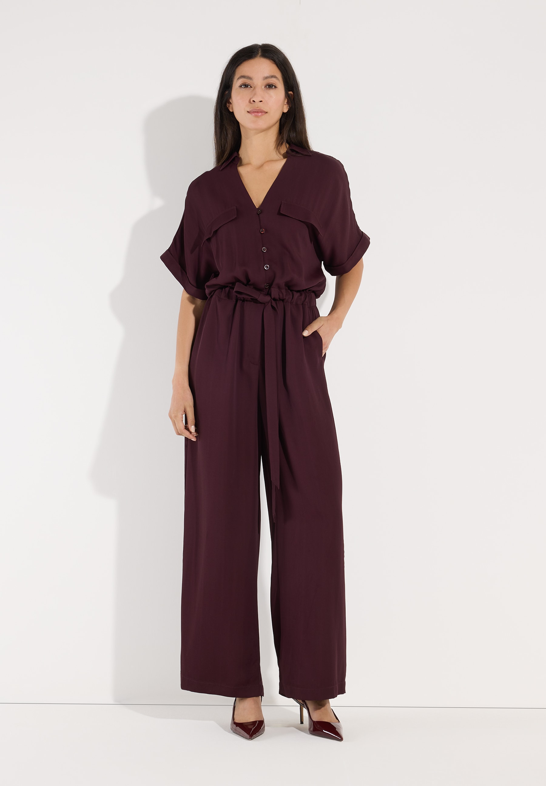 MORE & MORE Jumpsuit in Bordeaux, weite Passform, kurze Ärmel, V-Ausschnitt, Gürtel. MORE & MORE Jumpsuit in Bordeaux, weite Passform, kurze Ärmel, V-Ausschnitt, Gürtel.