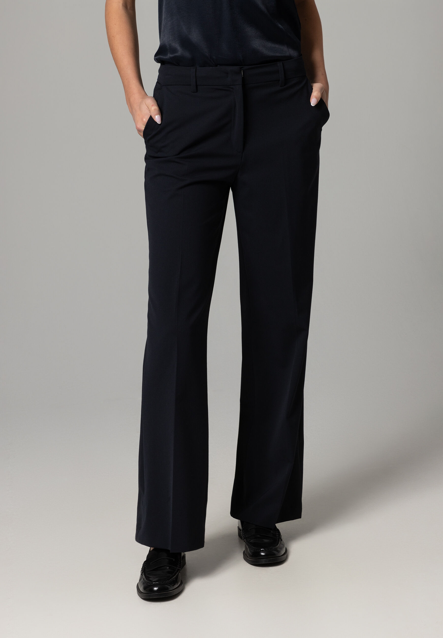 Eine Person in MORE & MORE Stretch-Gabardine-Hosen, die lässig in den Hosentaschen posiert. Eine Person in MORE & MORE Stretch-Gabardine-Hosen, die lässig in den Hosentaschen posiert.