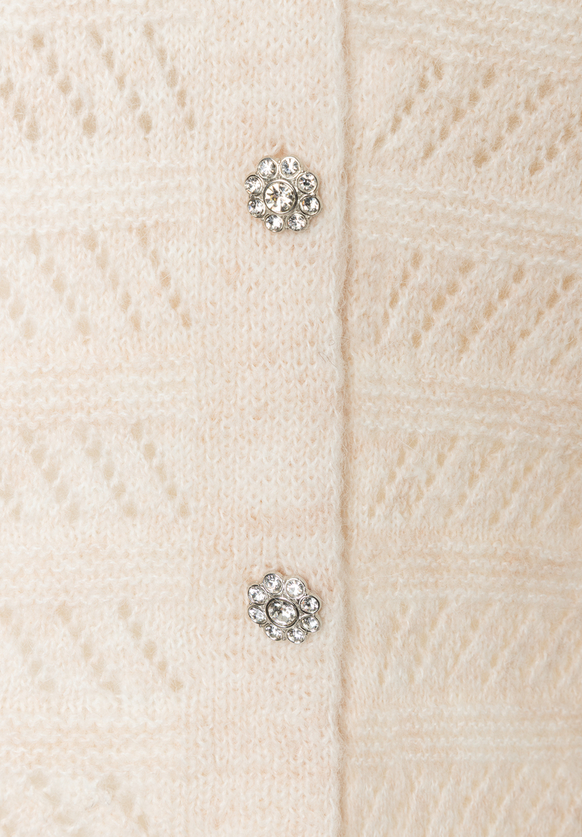 MORE & MORE Strickpullover: Nahaufnahme eines cremefarbenen Pullovers mit floralen, glitzernden Knopfdetails. MORE & MORE Strickpullover: Nahaufnahme eines cremefarbenen Pullovers mit floralen, glitzernden Knopfdetails.