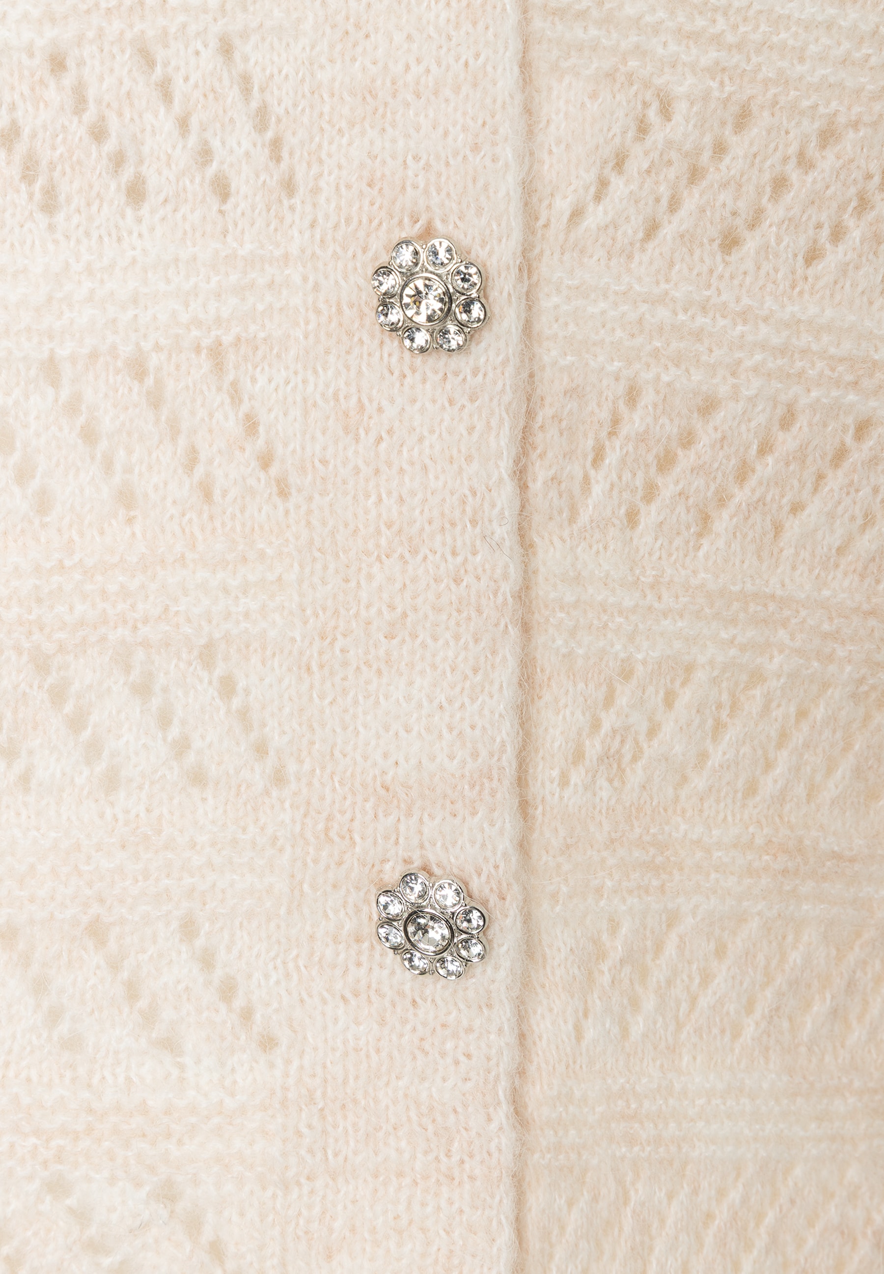 MORE & MORE Strickpullover: Nahaufnahme eines cremefarbenen Pullovers mit floralen, glitzernden Knopfdetails. MORE & MORE Strickpullover: Nahaufnahme eines cremefarbenen Pullovers mit floralen, glitzernden Knopfdetails.