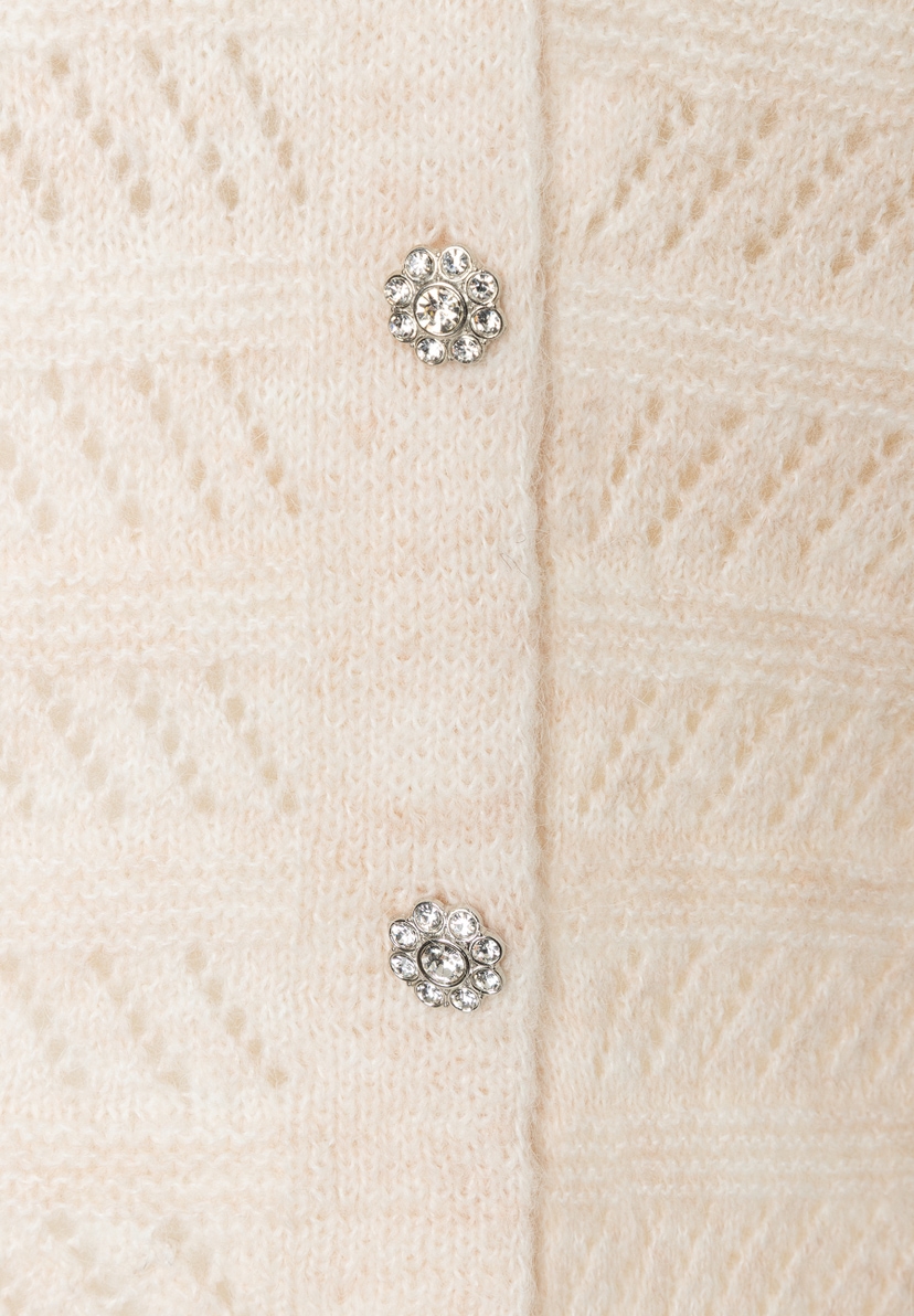 MORE & MORE Strickpullover: Nahaufnahme eines cremefarbenen Pullovers mit floralen, glitzernden Knopfdetails. MORE & MORE Strickpullover: Nahaufnahme eines cremefarbenen Pullovers mit floralen, glitzernden Knopfdetails.