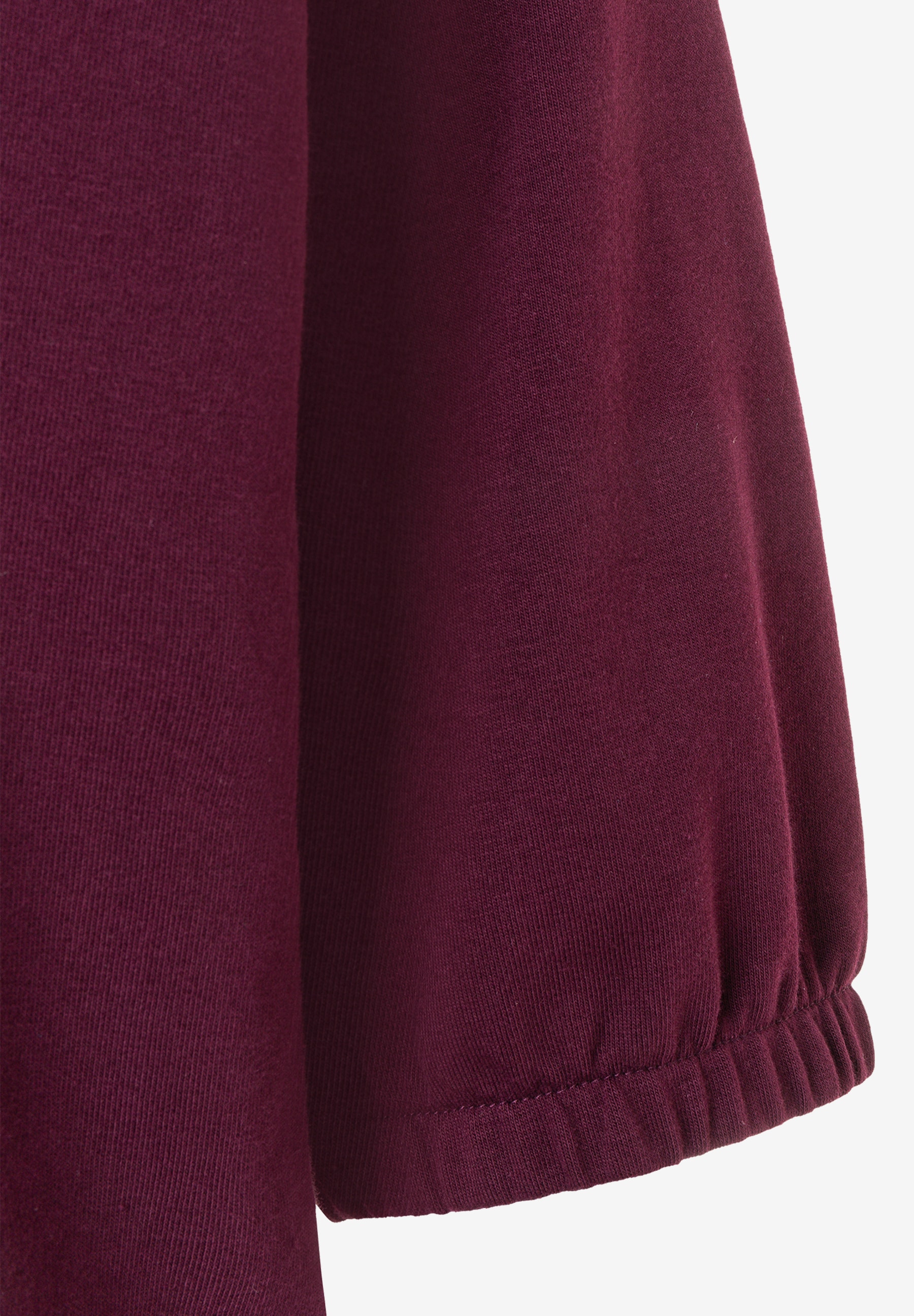 MORE & MORE Sweatshirt: Nahaufnahme des Ärmels eines weinroten MORE & MORE Sweatshirts mit Gummizugbündchen. MORE & MORE Sweatshirt: Nahaufnahme des Ärmels eines weinroten MORE & MORE Sweatshirts mit Gummizugbündchen.