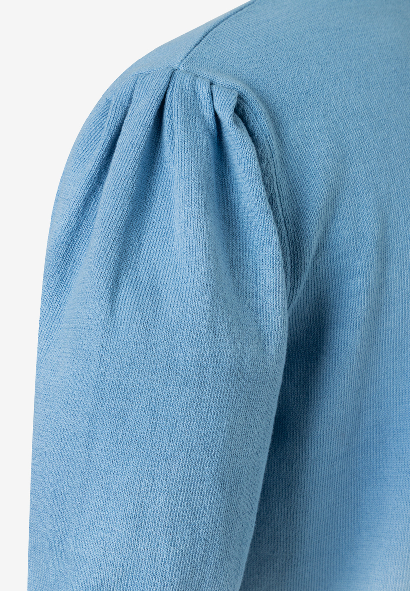 Detailaufnahme eines hellblauen MORE & MORE Oberteils mit Puffärmel. Detailaufnahme eines hellblauen MORE & MORE Oberteils mit Puffärmel.