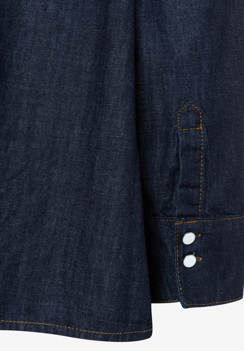 Detail einer blauen Jeansbluse von MORE & MORE, Manschette mit zwei Knöpfen. Detail einer blauen Jeansbluse von MORE & MORE, Manschette mit zwei Knöpfen.