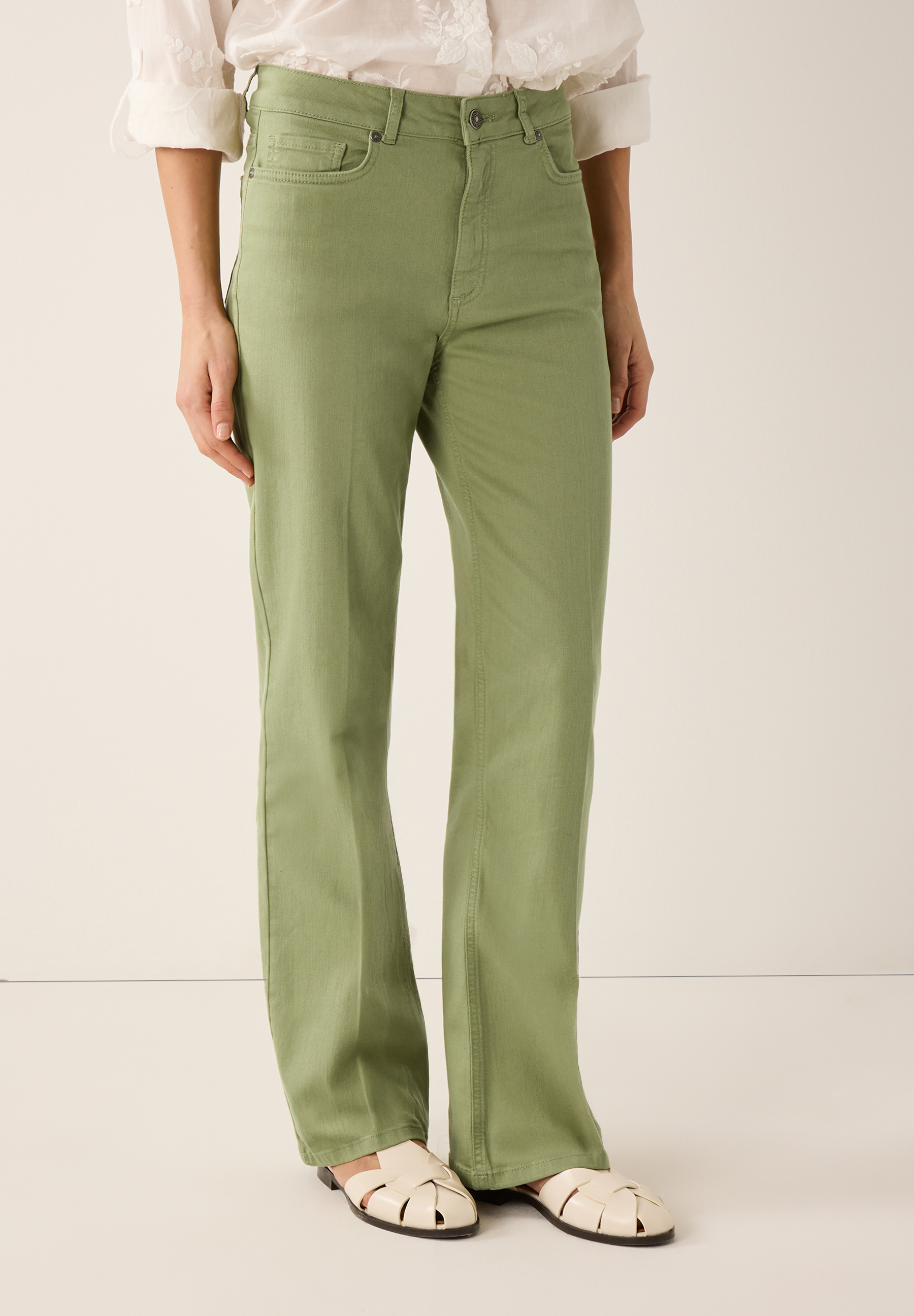 Eine Person trägt eine grüne MORE & MORE Jeanshose. Die Hose ist lässig geschnitten. Eine Person trägt eine grüne MORE & MORE Jeanshose. Die Hose ist lässig geschnitten.