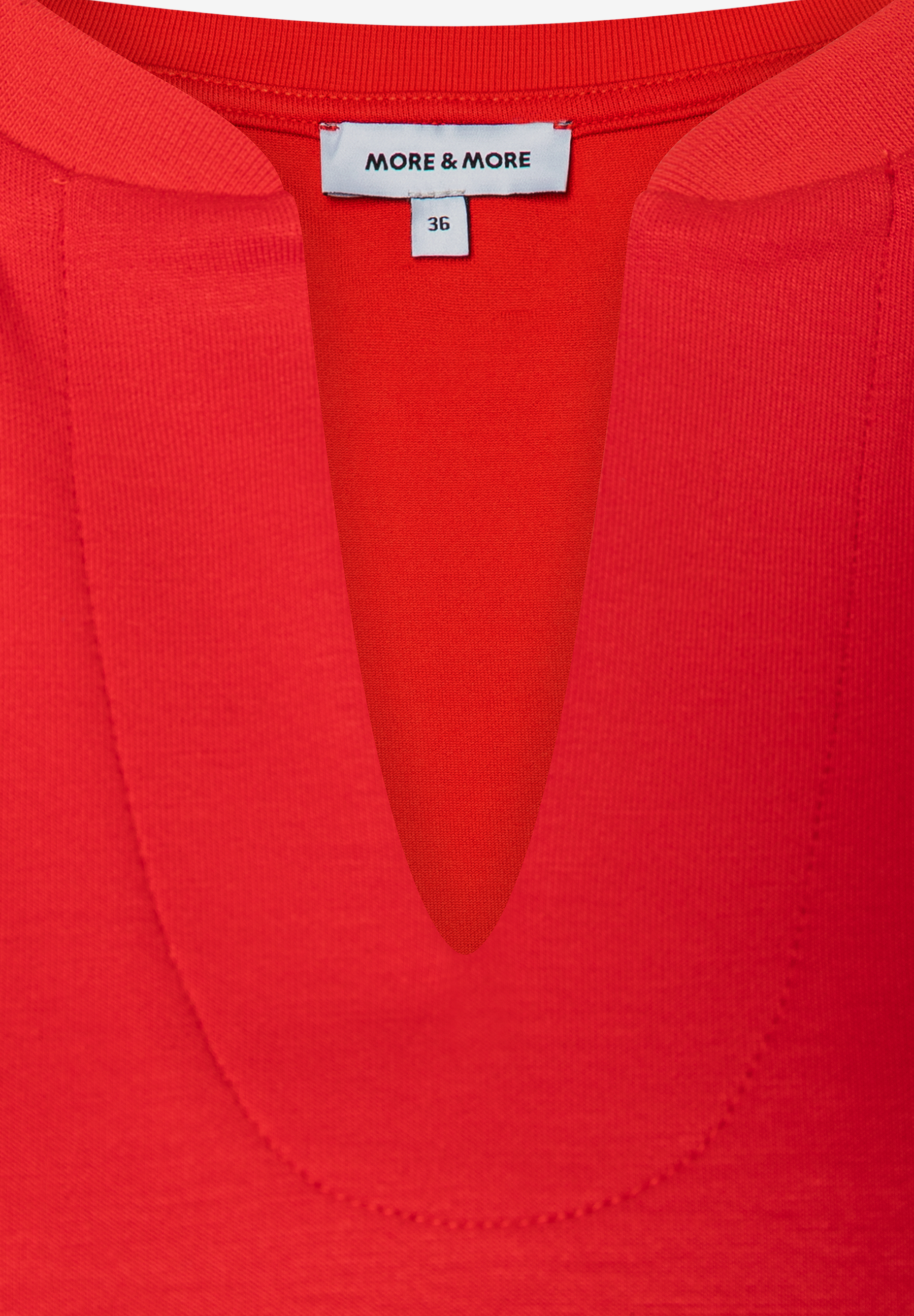 Nahaufnahme eines roten MORE & MORE Sweatshirts mit V-Ausschnitt und Größenetikett. Nahaufnahme eines roten MORE & MORE Sweatshirts mit V-Ausschnitt und Größenetikett.