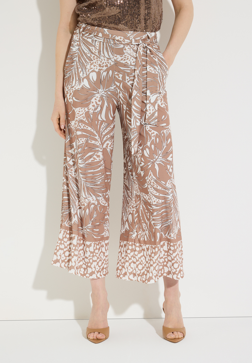 Eine MORE & MORE Hose mit Blattmuster und passenden Sandalen.