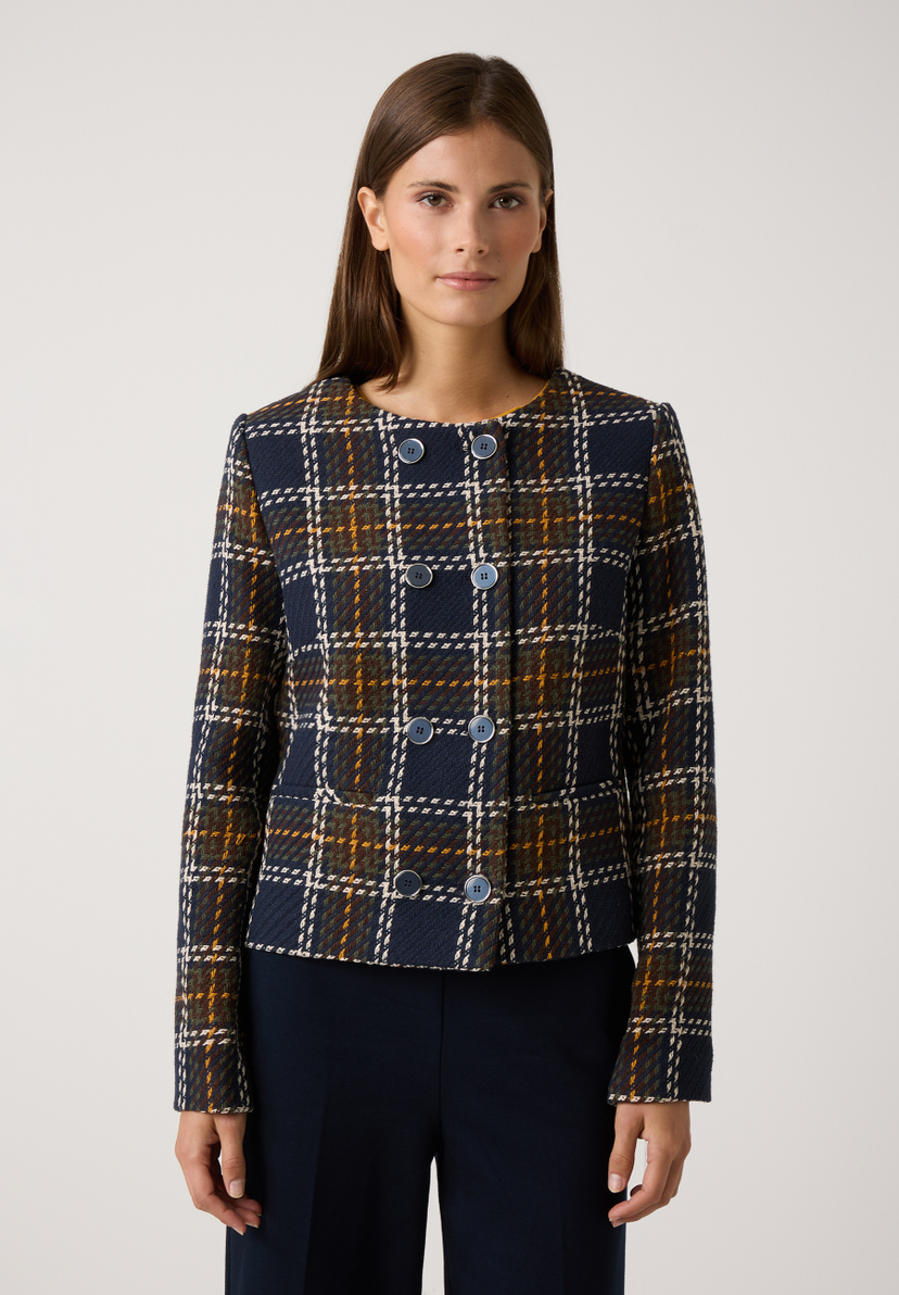 Eine Frau trägt einen MORE & MORE Blazer mit Karomuster in Blau, Braun und Gelb vor einem weißen Hintergrund. Eine Frau trägt einen MORE & MORE Blazer mit Karomuster in Blau, Braun und Gelb vor einem weißen Hintergrund.