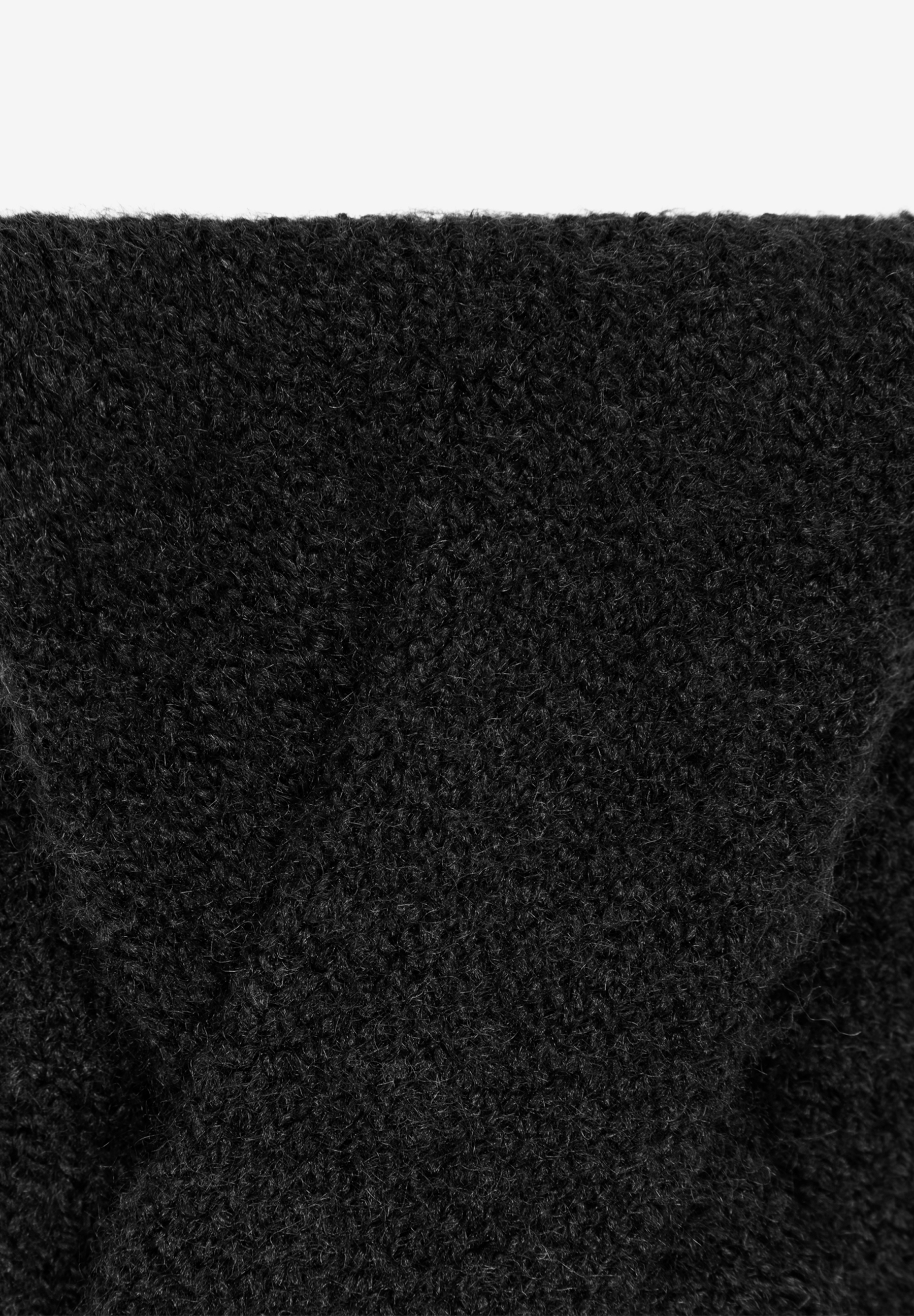 Nahaufnahme eines MORE & MORE Accessoires, ein schwarzer, flauschiger Stoff mit kurzen Fasern ist zu sehen.