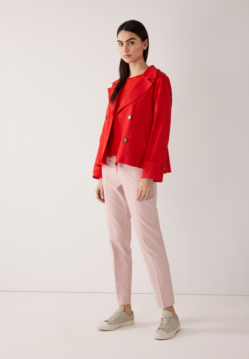 Eine Frau trägt einen roten MORE & MORE Blazer aus Twill, eine rote Bluse und rosa Hosen. Eine Frau trägt einen roten MORE & MORE Blazer aus Twill, eine rote Bluse und rosa Hosen.