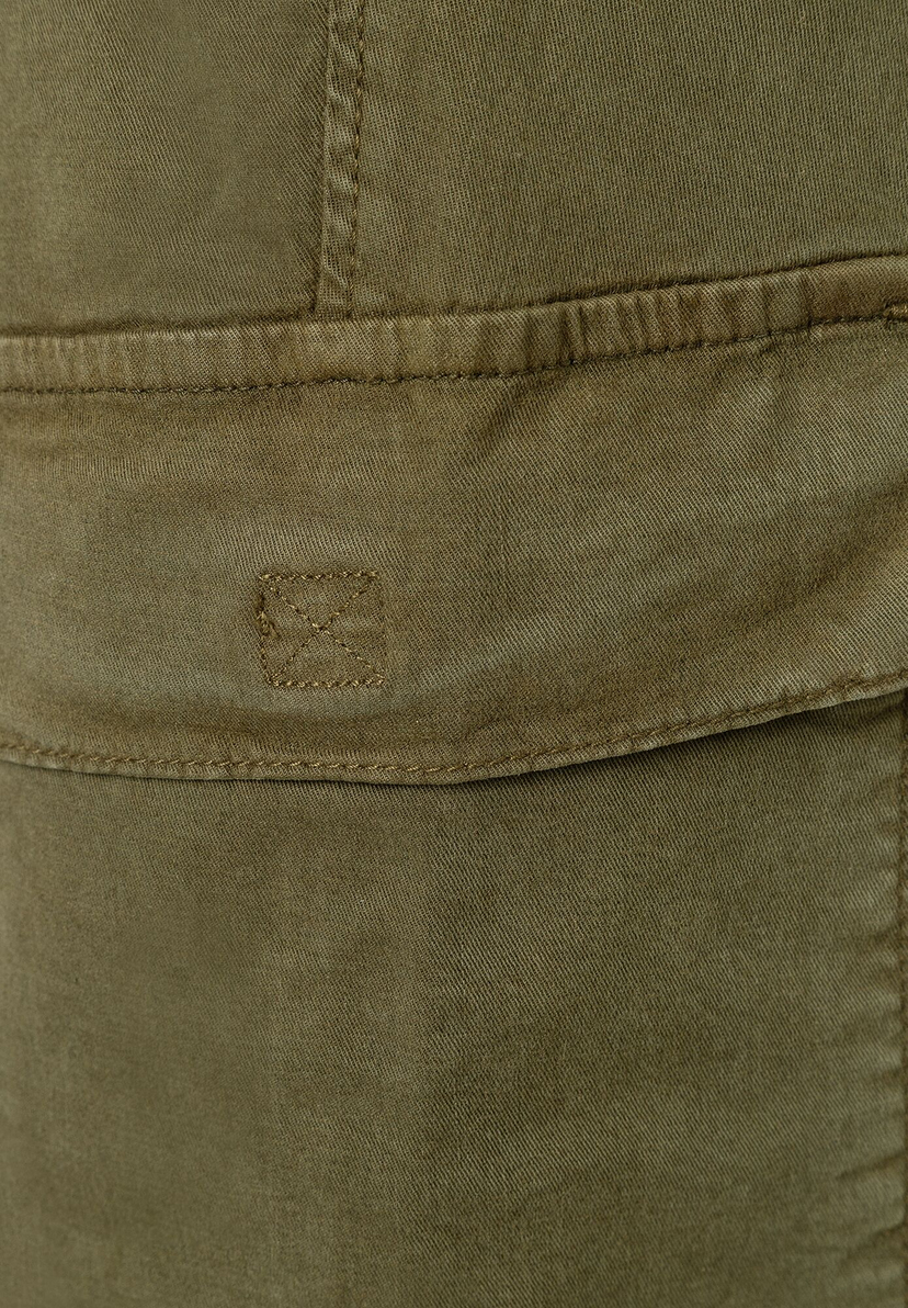 Nahaufnahme einer olivgrünen MORE & MORE Stretch-Denim-Hose mit Tasche und kleinem Logo.