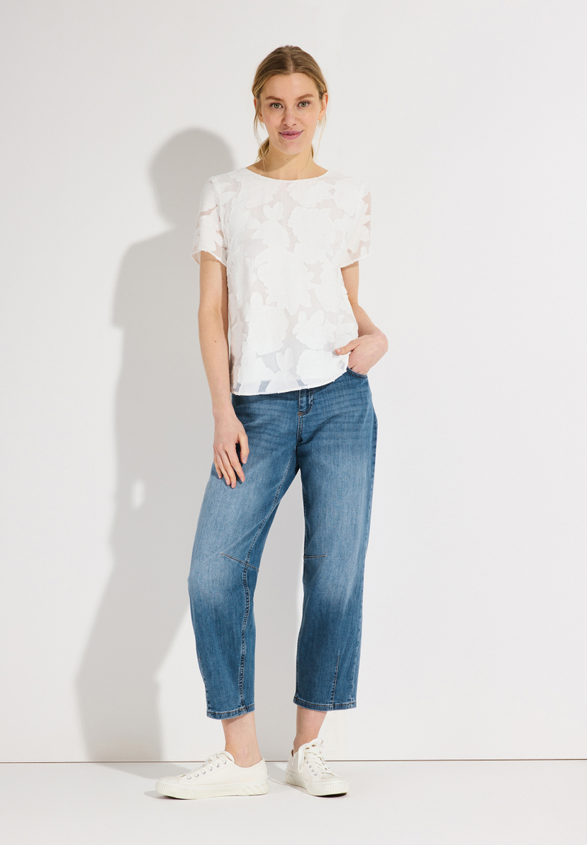Eine Frau steht in MORE & MORE Jeans vor einem weißen Hintergrund. Eine Frau steht in MORE & MORE Jeans vor einem weißen Hintergrund.