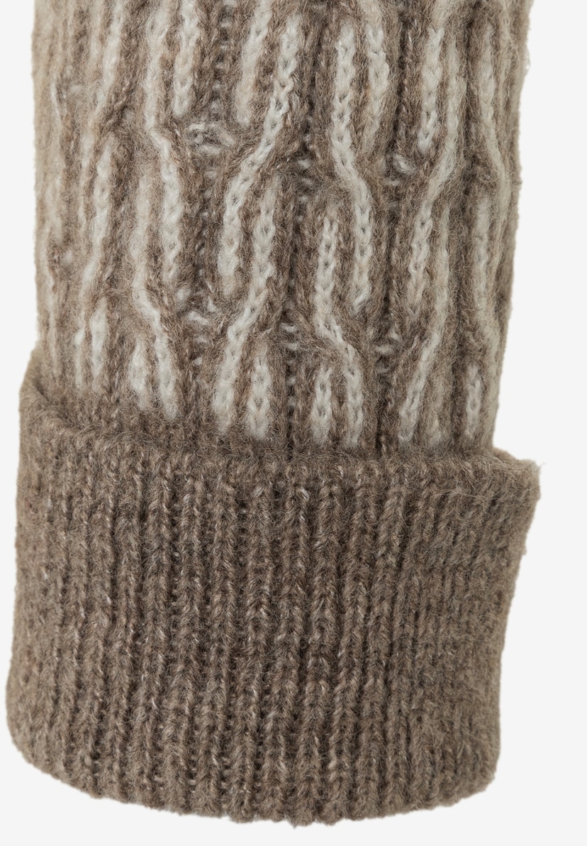 Detailaufnahme eines MORE & MORE Oberteils aus Jacquard-Strick mit Zopfmuster und Umschlag. Detailaufnahme eines MORE & MORE Oberteils aus Jacquard-Strick mit Zopfmuster und Umschlag.