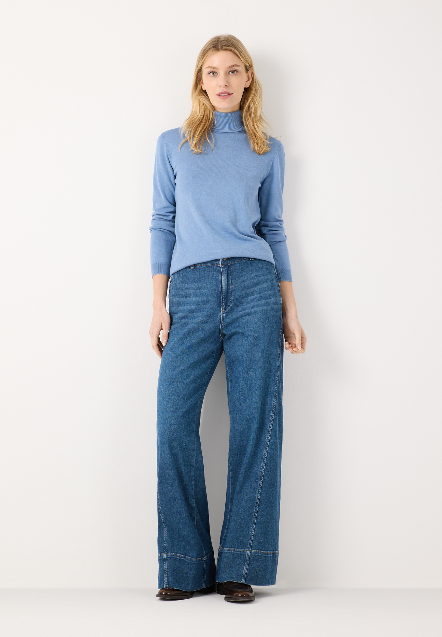 MORE & MORE Jeans: Helle Jeans mit weitem Bein und hellem Rollkragenpullover vor weißem Hintergrund. MORE & MORE Jeans: Helle Jeans mit weitem Bein und hellem Rollkragenpullover vor weißem Hintergrund.