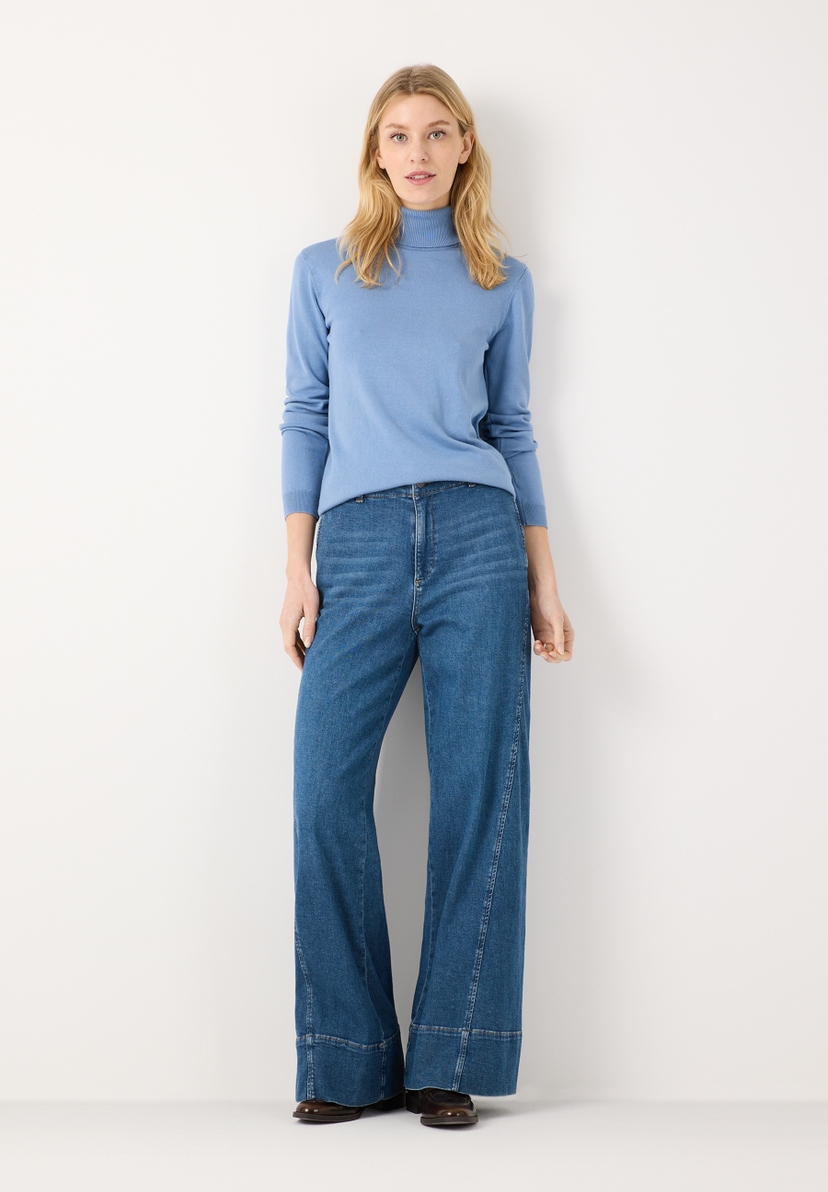 MORE & MORE Jeans: Helle Jeans mit weitem Bein und hellem Rollkragenpullover vor weißem Hintergrund. MORE & MORE Jeans: Helle Jeans mit weitem Bein und hellem Rollkragenpullover vor weißem Hintergrund.