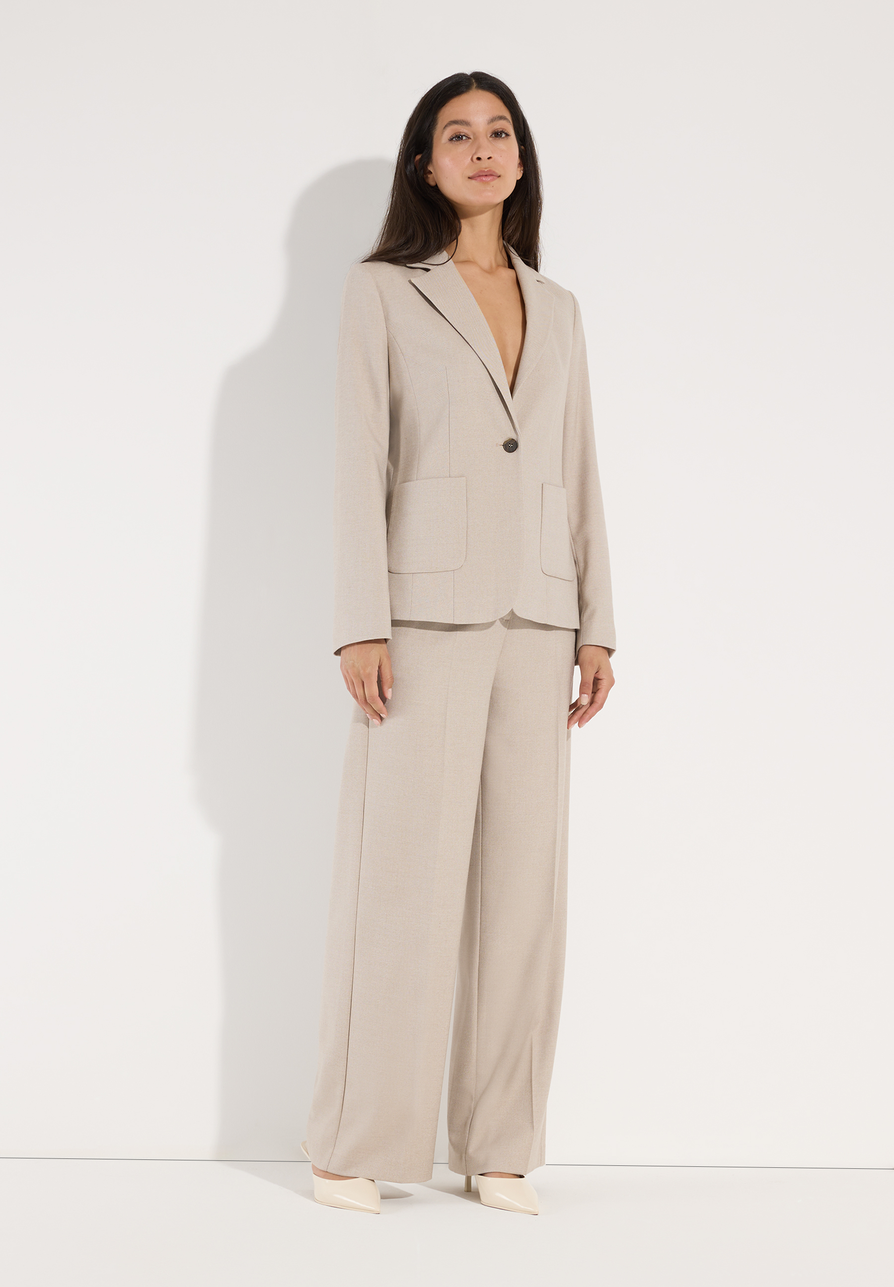 MORE & MORE Blazer Webware in Beige getragen von einem Model vor hellem Hintergrund. Die Hose hat einen weiten Schnitt. MORE & MORE Blazer Webware in Beige getragen von einem Model vor hellem Hintergrund. Die Hose hat einen weiten Schnitt.