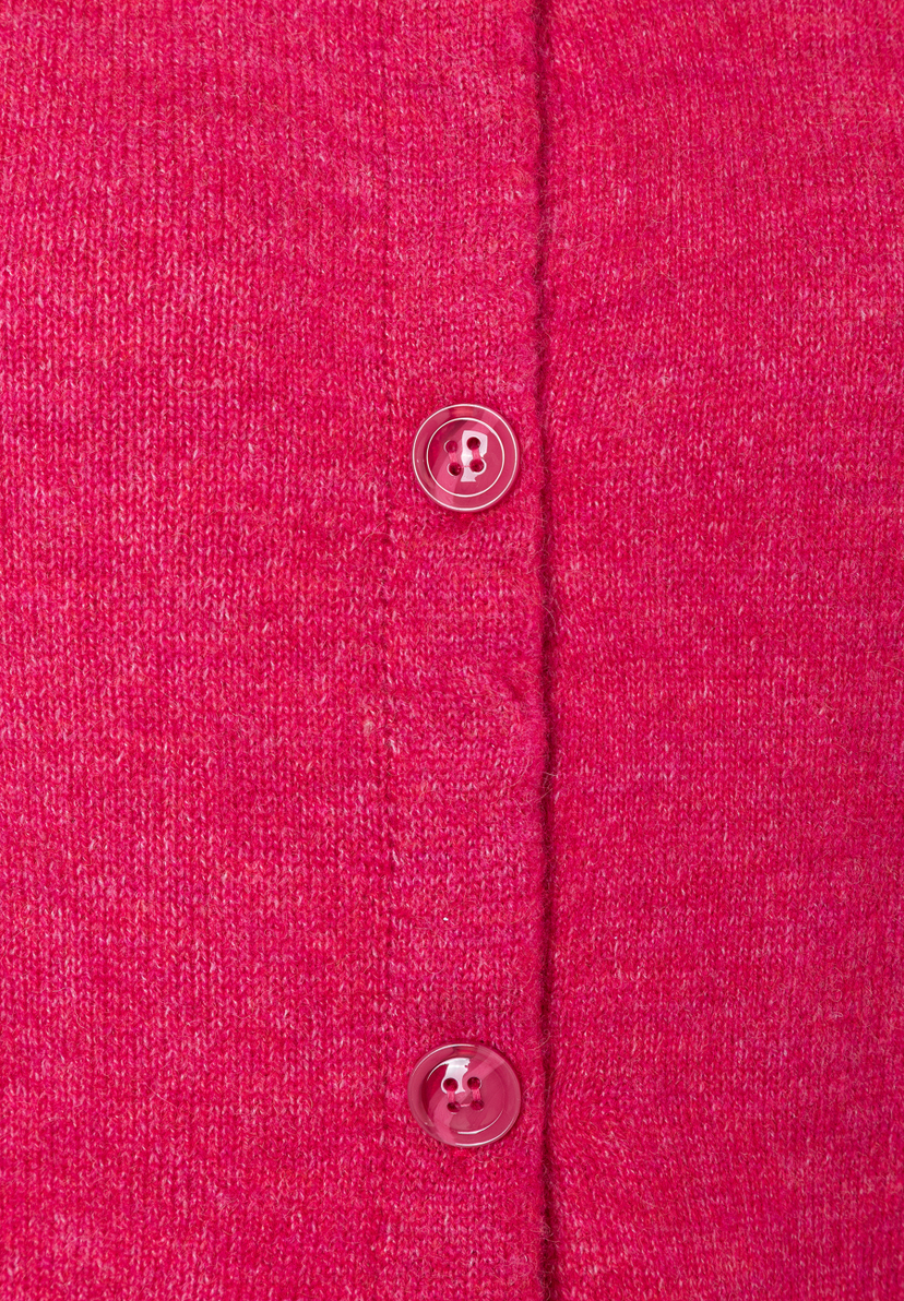 Nahaufnahme eines pinkfarbenen Strickoberteils von MORE & MORE mit Knöpfen. Nahaufnahme eines pinkfarbenen Strickoberteils von MORE & MORE mit Knöpfen.