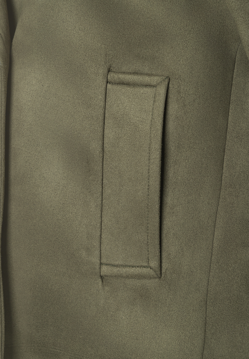 Nahaufnahme eines MORE & MORE Oberteils aus Kunstleder mit softer Oberfläche und aufgesetzter Tasche. Nahaufnahme eines MORE & MORE Oberteils aus Kunstleder mit softer Oberfläche und aufgesetzter Tasche.