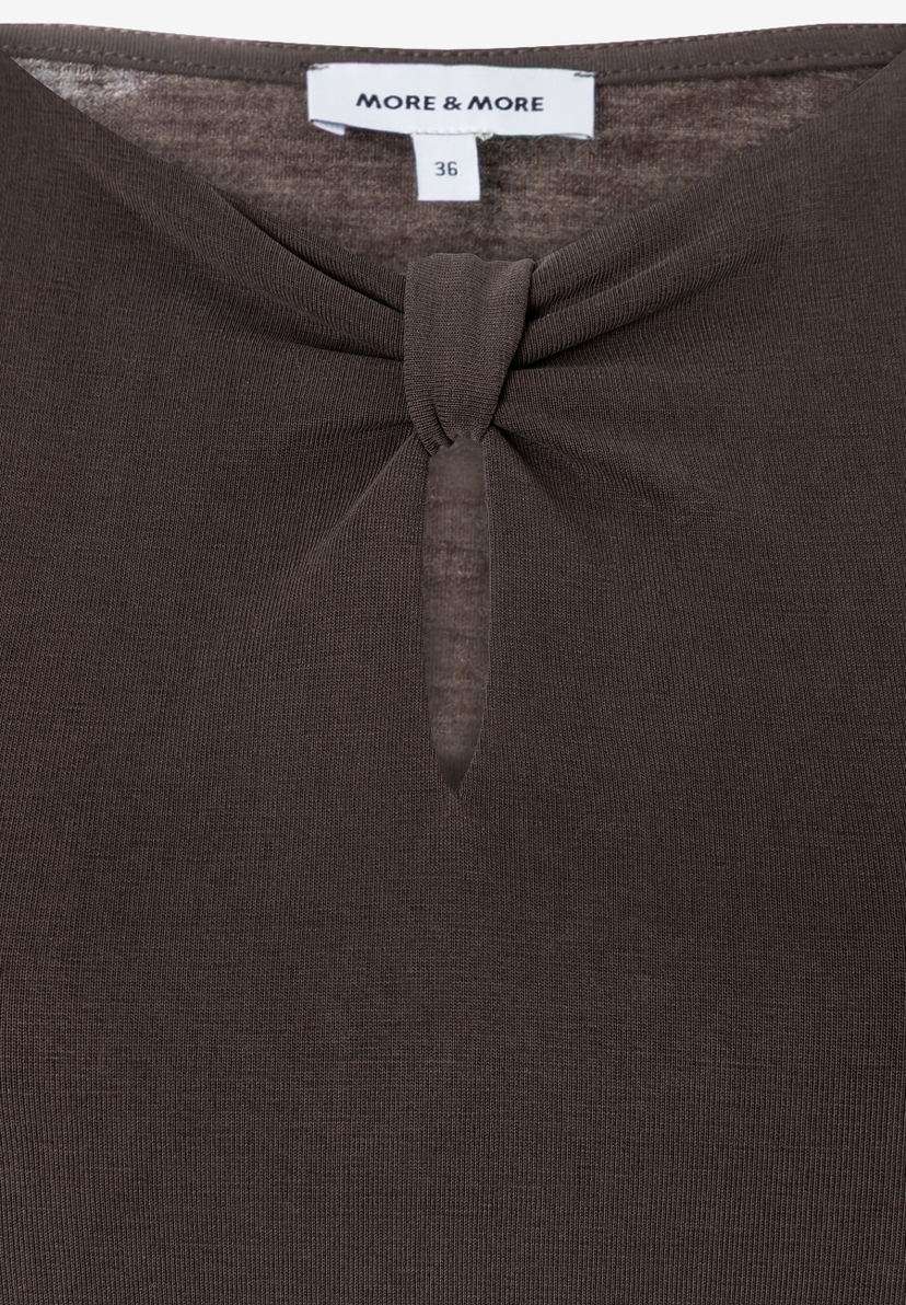 MORE & MORE Jersey-Oberteil in Braun. Enganliegendes Shirt mit elegantem Knoten und Cut-Out unter dem Rundhalsausschnitt. MORE & MORE Jersey-Oberteil in Braun. Enganliegendes Shirt mit elegantem Knoten und Cut-Out unter dem Rundhalsausschnitt.