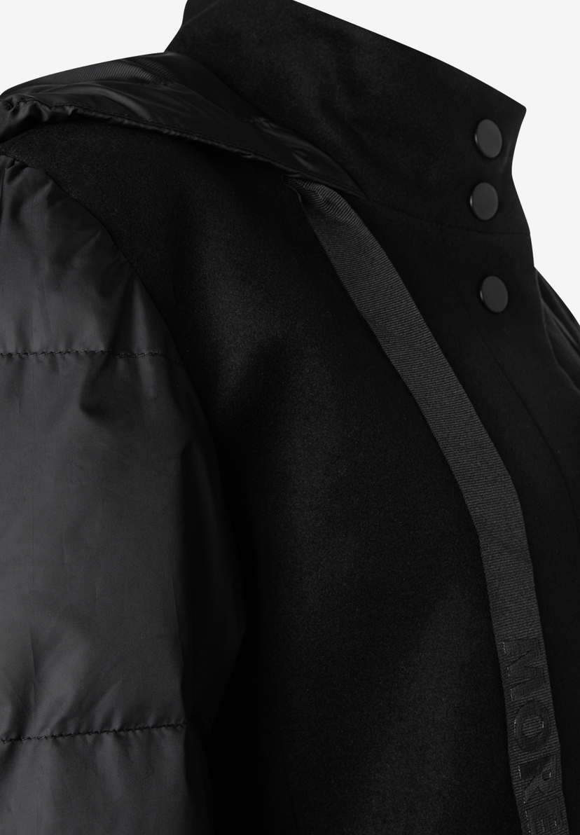 MORE & MORE schwarze Jacke mit Stehkragen und Druckknöpfen. Wattierte Ärmel kontrastieren mit dem Wollstoff.