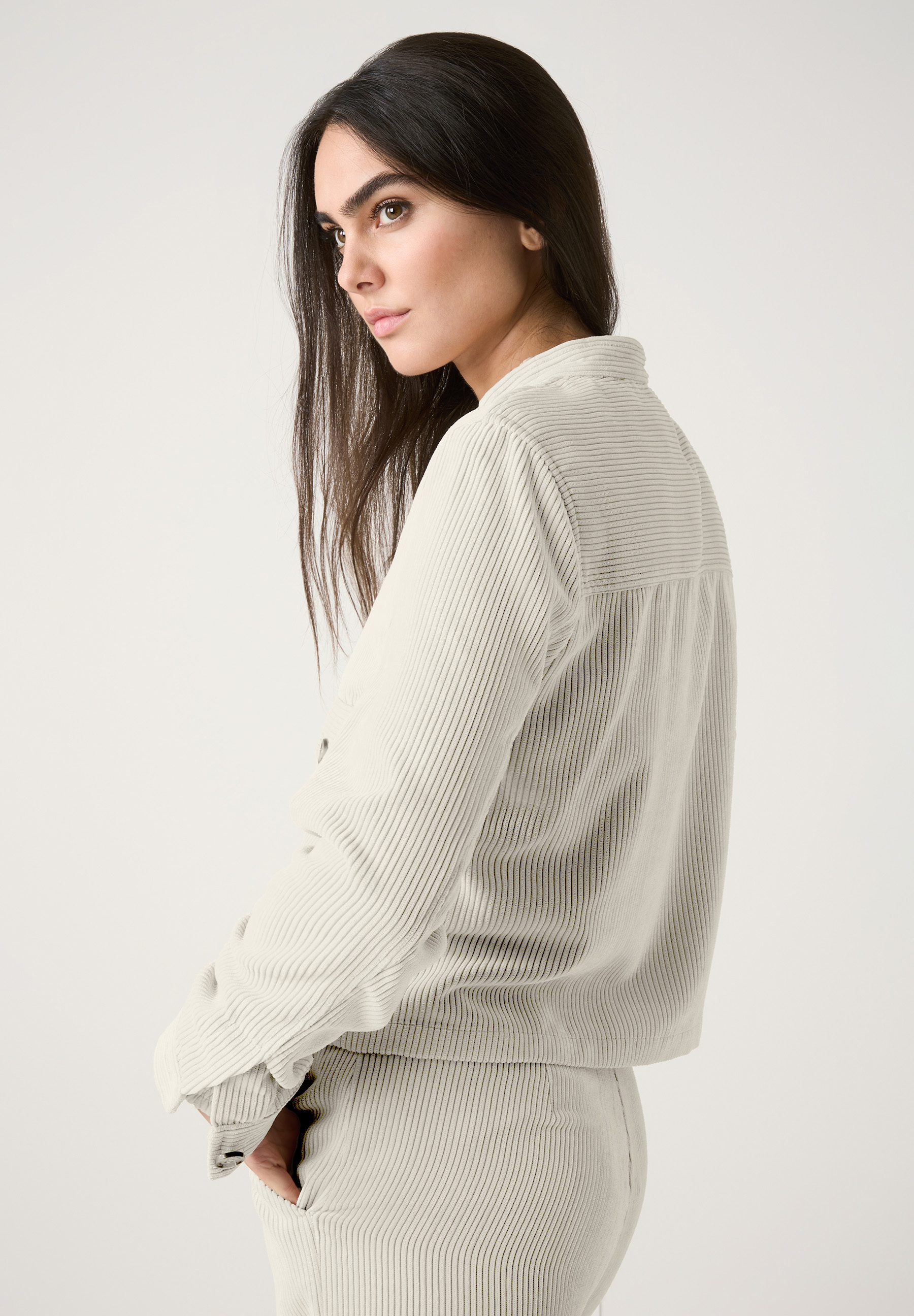 Eine Frau mit MORE & MORE Oberteil aus Cord, das für angenehmen Tragekomfort und Elastizität sorgt. Eine Frau mit MORE & MORE Oberteil aus Cord, das für angenehmen Tragekomfort und Elastizität sorgt.