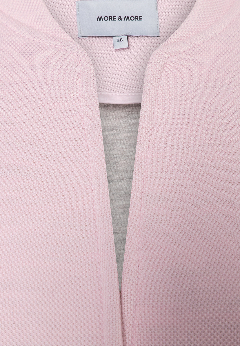 Nahaufnahme eines MORE & MORE Blazers aus Piqué-Jersey in Rosa mit Größenetikett 36. Nahaufnahme eines MORE & MORE Blazers aus Piqué-Jersey in Rosa mit Größenetikett 36.