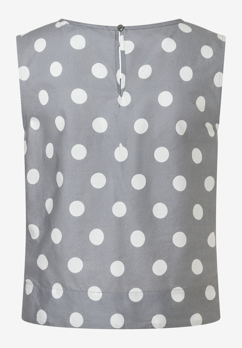Eine ärmellose MORE & MORE Bluse mit weißen Punkten auf grauem Stoff. Popeline mit Knopf im Nacken. Eine ärmellose MORE & MORE Bluse mit weißen Punkten auf grauem Stoff. Popeline mit Knopf im Nacken.