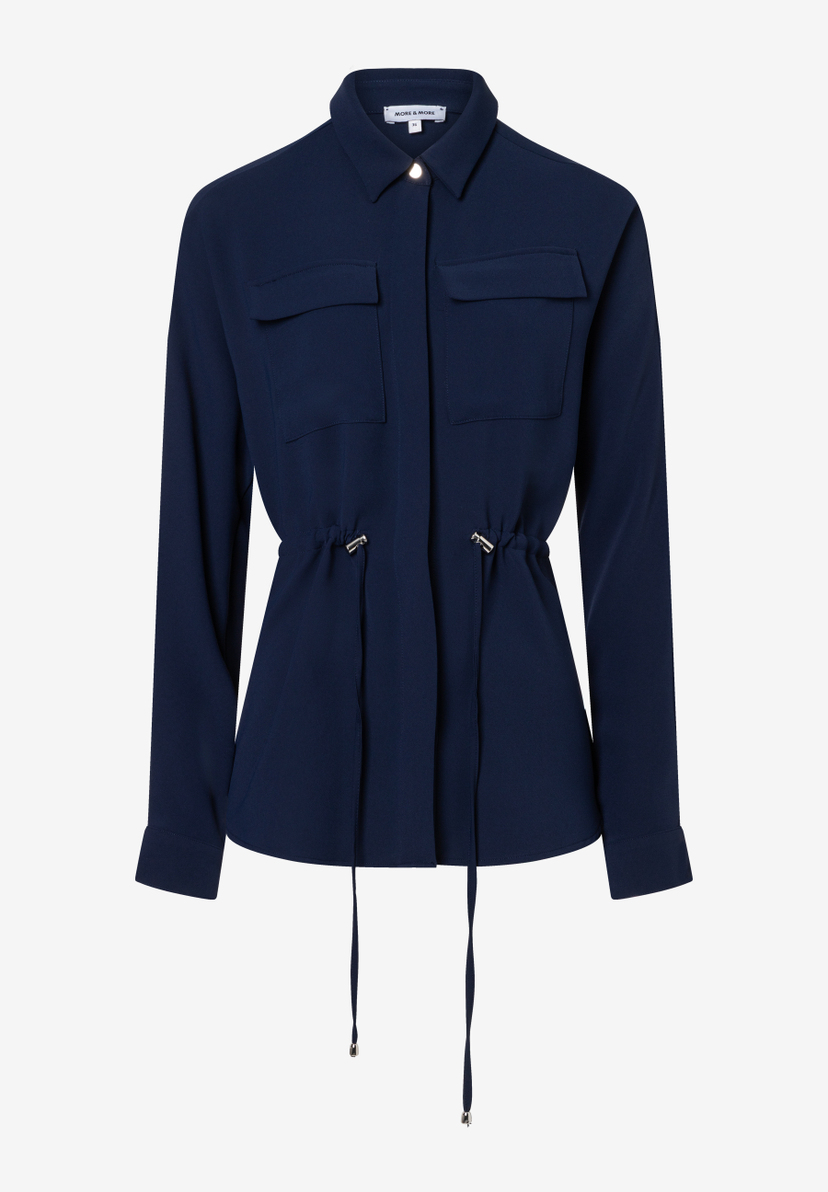 Eine dunkelblaue MORE & MORE Bluse mit langen Ärmeln und Kordelzug in der Taille. Eine dunkelblaue MORE & MORE Bluse mit langen Ärmeln und Kordelzug in der Taille.