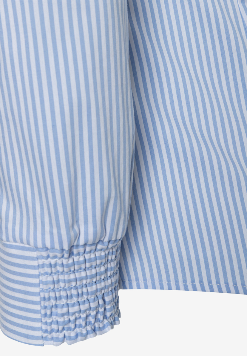 Detailansicht einer MORE & MORE Bluse mit blau-weißem Streifenmuster und elastischen Details. Detailansicht einer MORE & MORE Bluse mit blau-weißem Streifenmuster und elastischen Details.