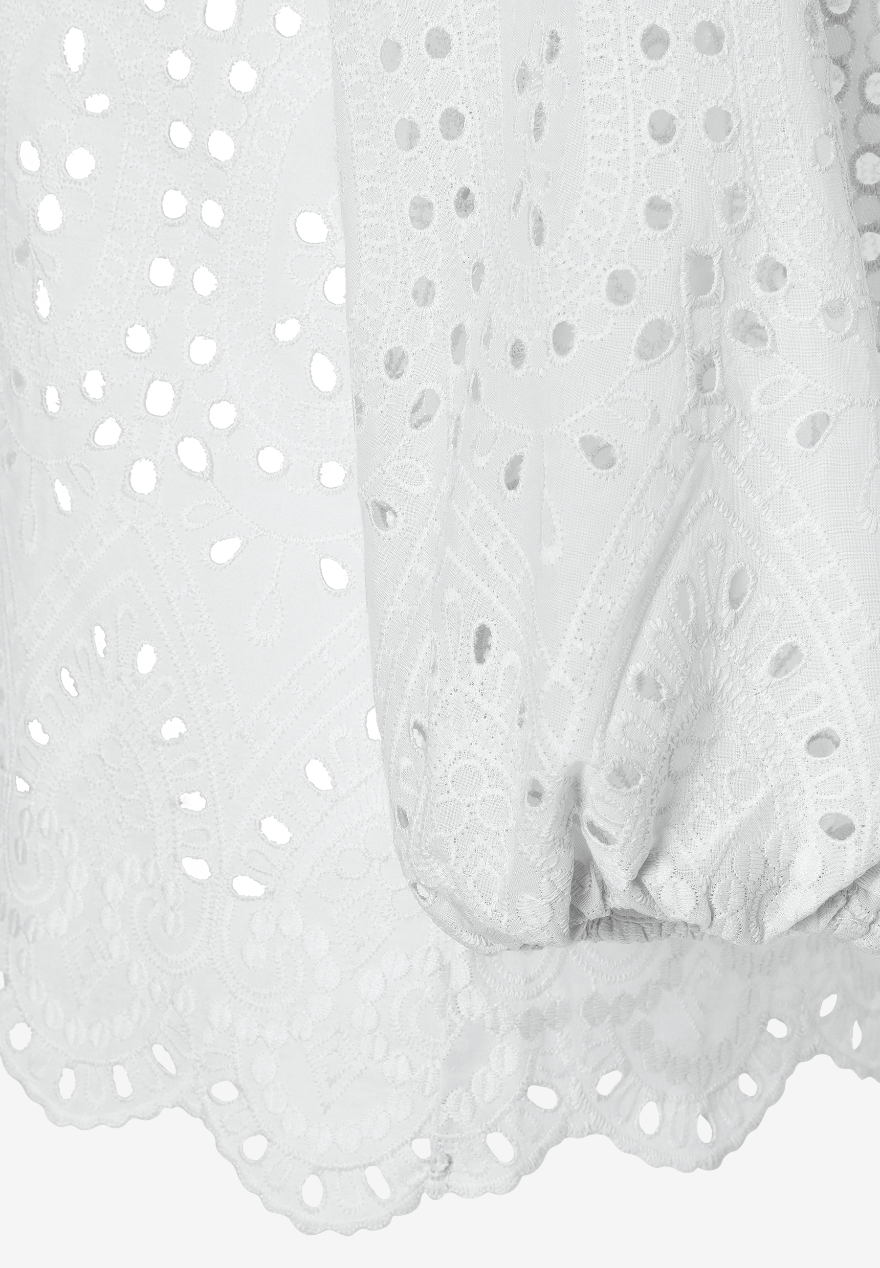 Detailaufnahme einer weißen MORE & MORE Bluse mit Spitze und Lochmuster, die einen angenehmen Tragekomfort bietet.