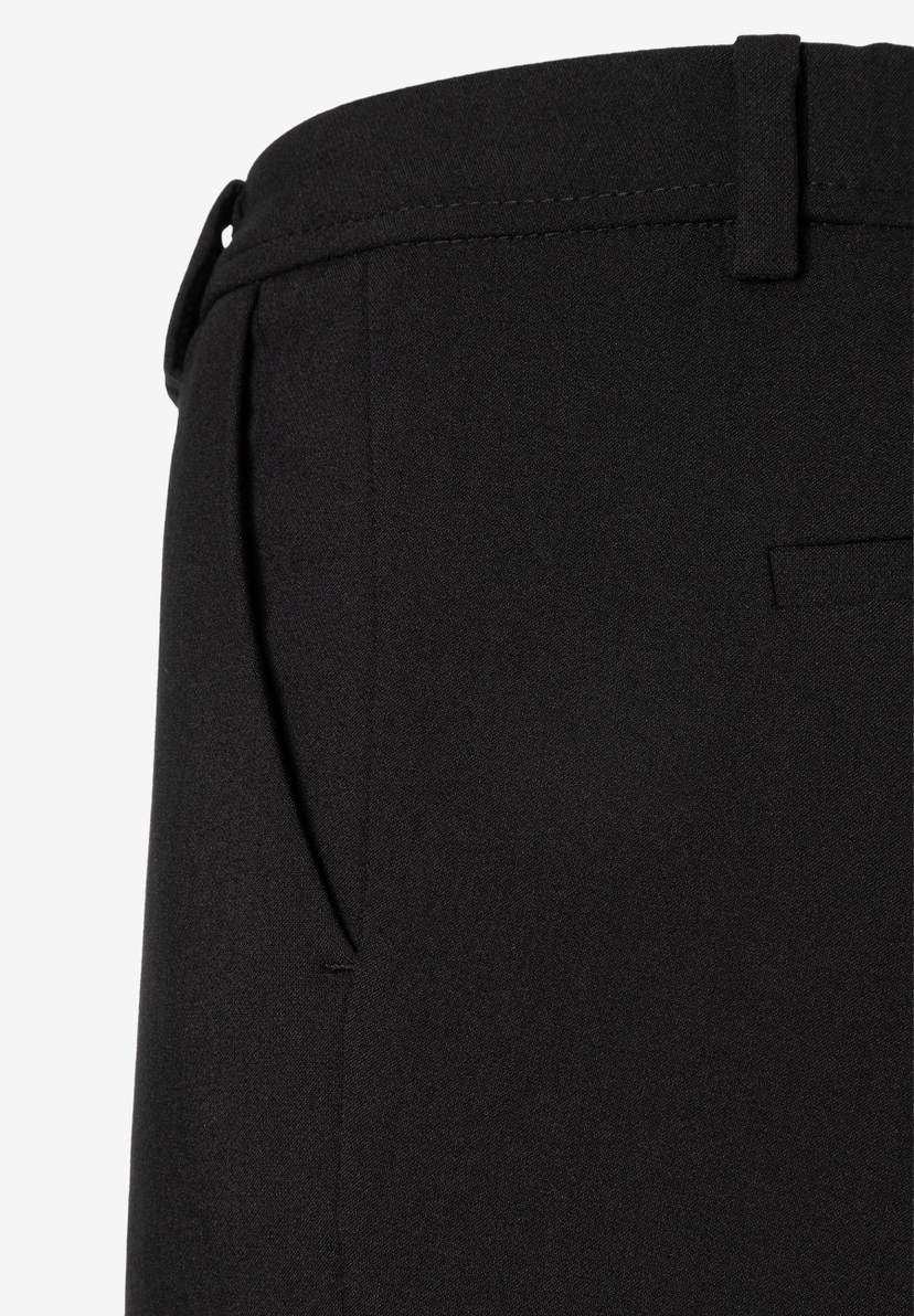 MORE & MORE Jeans: Nahaufnahme einer schwarzen Hose mit schrägen Vordertaschen, Gürtelschlaufen und leichter Stoffstruktur.