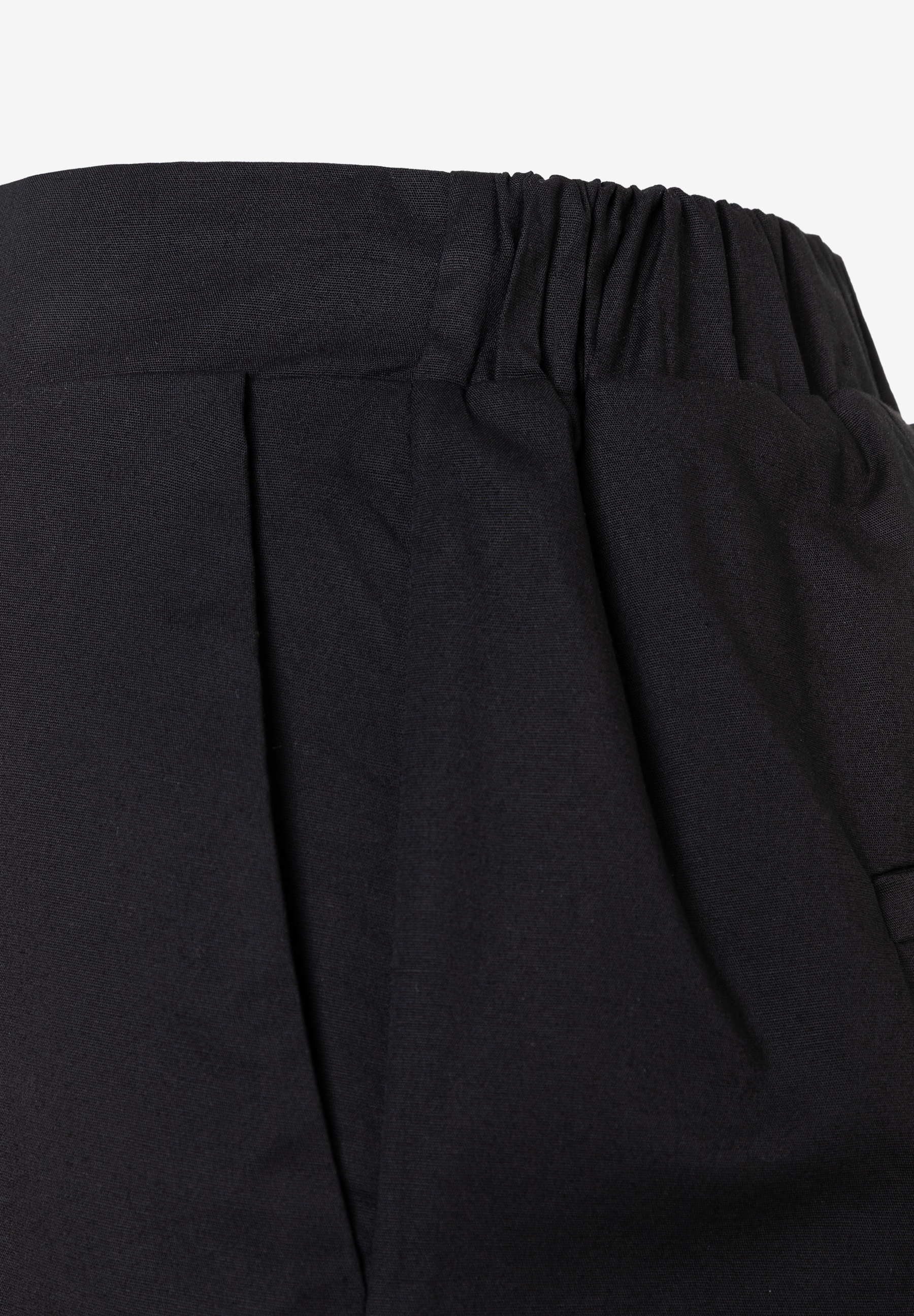 Detailaufnahme einer schwarzen, plissierten MORE & MORE Webware-Hose mit elastischem Bund für angenehmen Tragekomfort. Detailaufnahme einer schwarzen, plissierten MORE & MORE Webware-Hose mit elastischem Bund für angenehmen Tragekomfort.