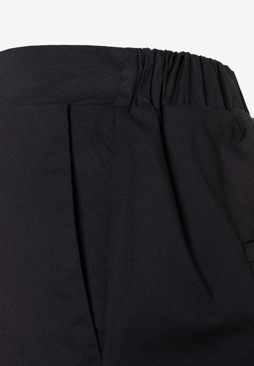 Detailaufnahme einer schwarzen, plissierten MORE & MORE Webware-Hose mit elastischem Bund für angenehmen Tragekomfort. Detailaufnahme einer schwarzen, plissierten MORE & MORE Webware-Hose mit elastischem Bund für angenehmen Tragekomfort.