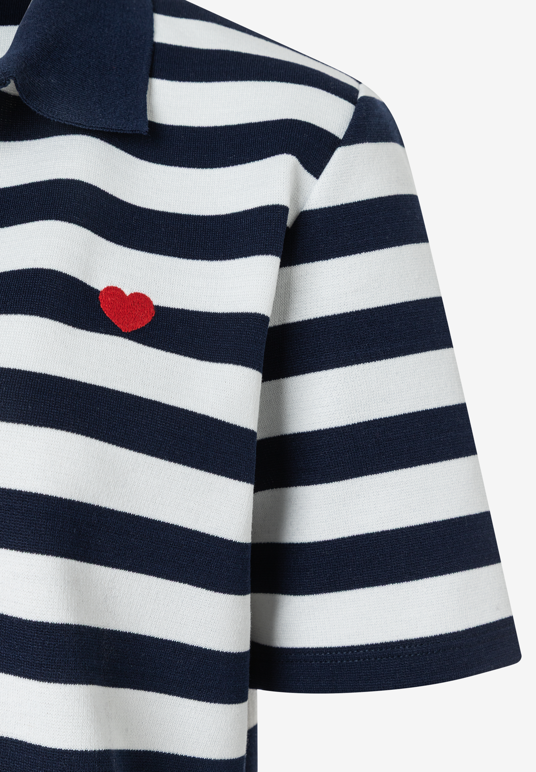 Detailaufnahme eines gestreiften MORE & MORE Oberteils mit kleinem roten Herz-Detail. Detailaufnahme eines gestreiften MORE & MORE Oberteils mit kleinem roten Herz-Detail.