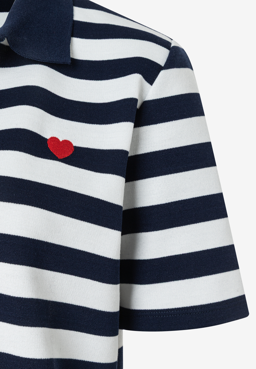 Detailaufnahme eines gestreiften MORE & MORE Oberteils mit kleinem roten Herz-Detail. Detailaufnahme eines gestreiften MORE & MORE Oberteils mit kleinem roten Herz-Detail.