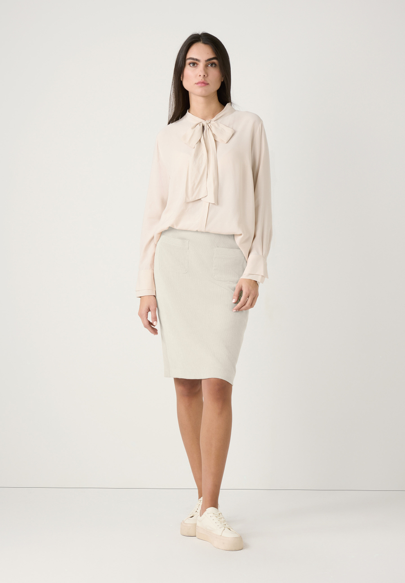 Eine Frau trägt ein elfenbeinfarbenes MORE & MORE Cordrock-Ensemble. Eine Frau trägt ein elfenbeinfarbenes MORE & MORE Cordrock-Ensemble.