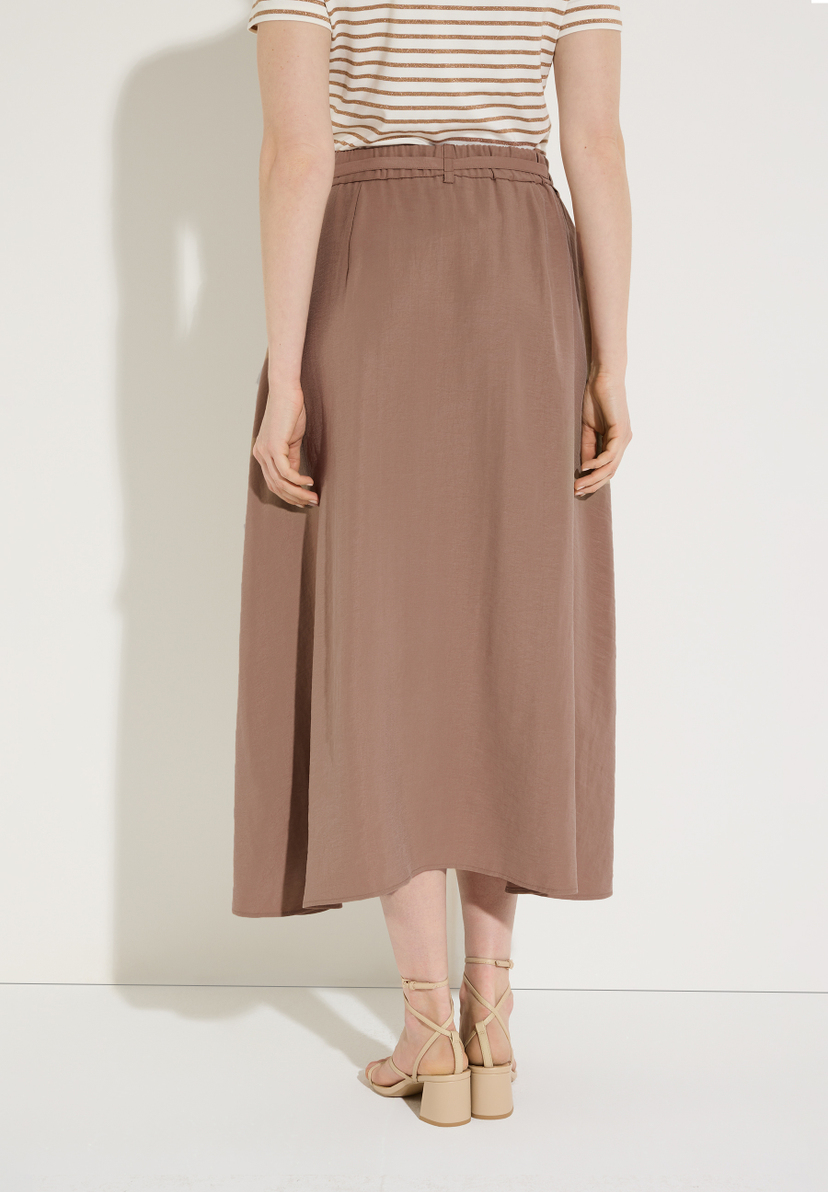 Die Rückansicht eines Models mit einem Rock der Marke MORE & MORE. Der Rock ist knöchellang und hat eine Webware-Konstruktion. Die Rückansicht eines Models mit einem Rock der Marke MORE & MORE. Der Rock ist knöchellang und hat eine Webware-Konstruktion.