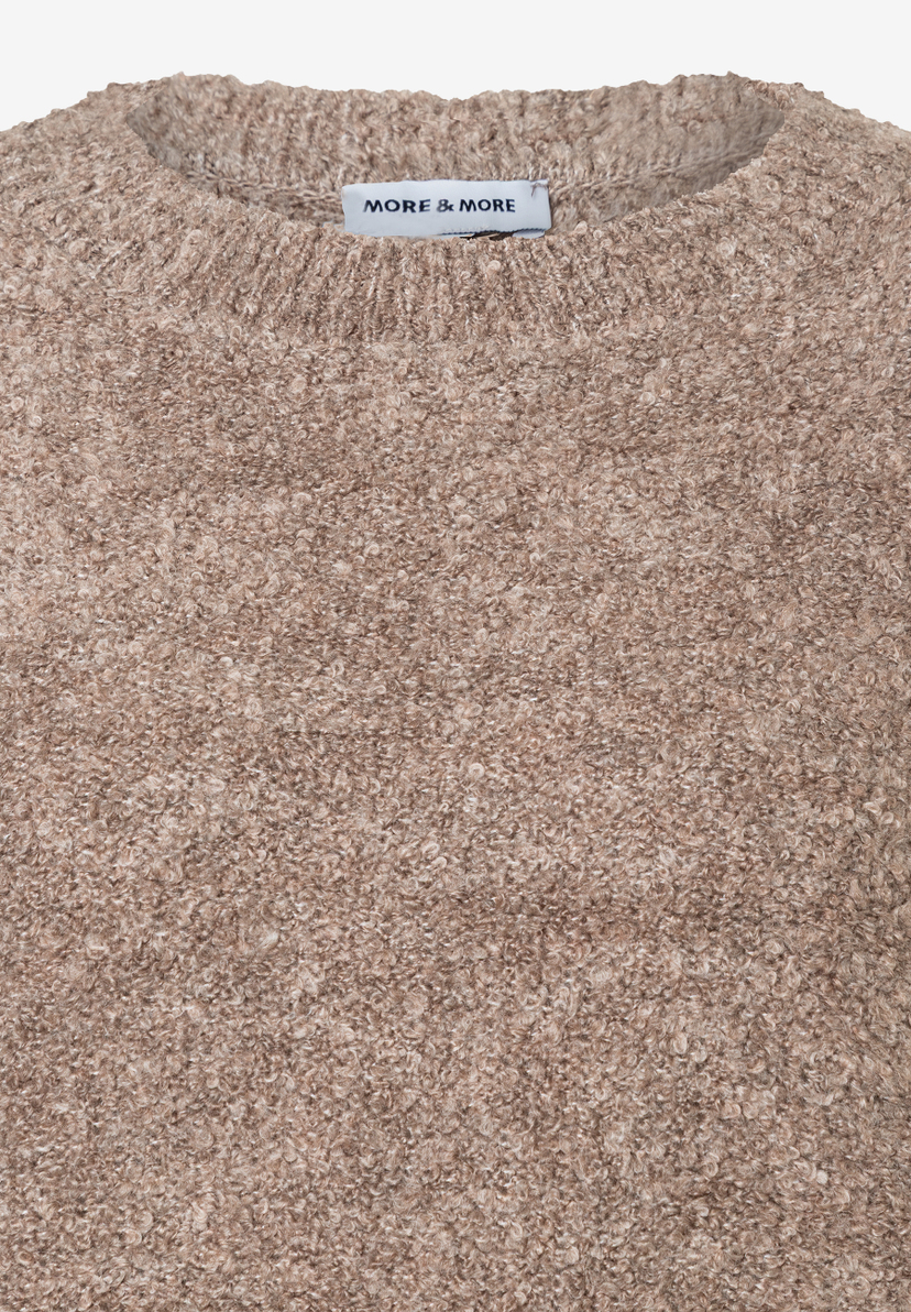 Nahaufnahme eines beigen Bouclé-Pullovers der Marke MORE & MORE, der warm und angenehm zu tragen ist. Nahaufnahme eines beigen Bouclé-Pullovers der Marke MORE & MORE, der warm und angenehm zu tragen ist.