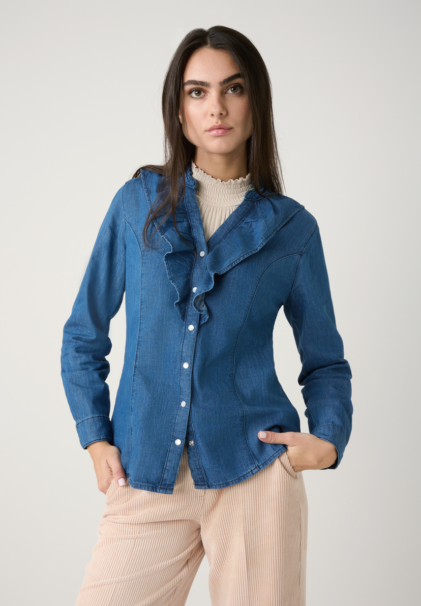 Eine Frau in einer blauen MORE & MORE Bluse mit Rüschen und beigen Hosen posiert vor einem neutralen Hintergrund. Eine Frau in einer blauen MORE & MORE Bluse mit Rüschen und beigen Hosen posiert vor einem neutralen Hintergrund.