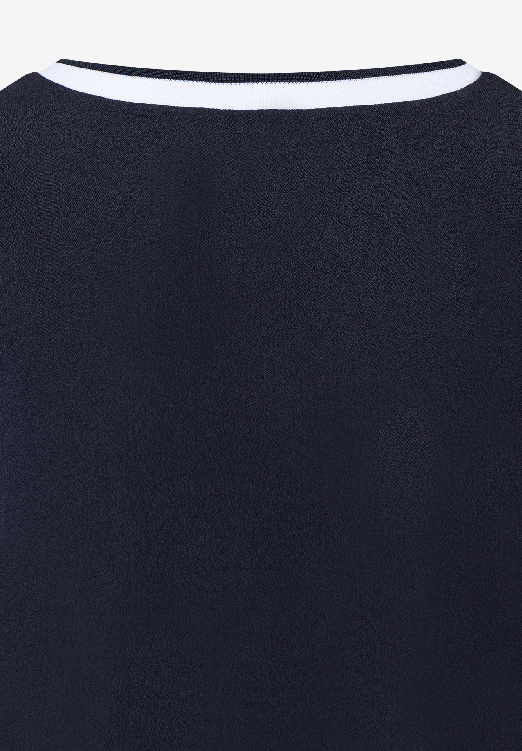 Detailansicht eines MORE & MORE Oberteils. Kragen mit weißen Streifen auf dunklem Stoff, angenehm und elastisch. Detailansicht eines MORE & MORE Oberteils. Kragen mit weißen Streifen auf dunklem Stoff, angenehm und elastisch.