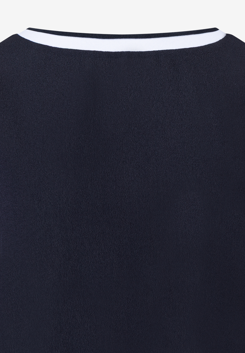 Detailansicht eines MORE & MORE Oberteils. Kragen mit weißen Streifen auf dunklem Stoff, angenehm und elastisch. Detailansicht eines MORE & MORE Oberteils. Kragen mit weißen Streifen auf dunklem Stoff, angenehm und elastisch.