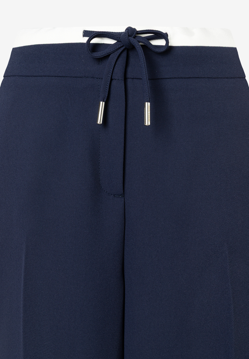 Detailaufnahme von MORE & MORE Hose mit Kordelzug in Marineblau und Weiß. Detailaufnahme von MORE & MORE Hose mit Kordelzug in Marineblau und Weiß.