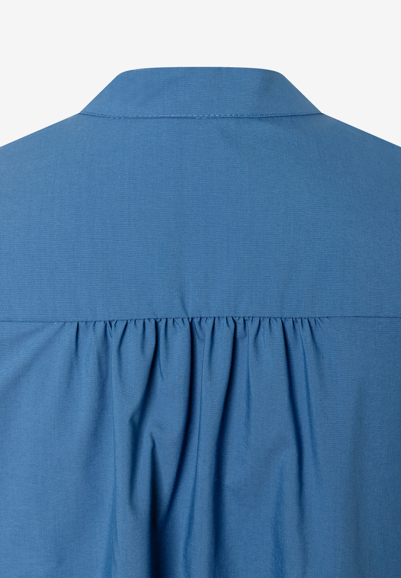 Nahaufnahme der Rückseite einer blauen MORE & MORE Bluse aus Popeline-Baumwollmischung mit Kragen und Falten. Nahaufnahme der Rückseite einer blauen MORE & MORE Bluse aus Popeline-Baumwollmischung mit Kragen und Falten.